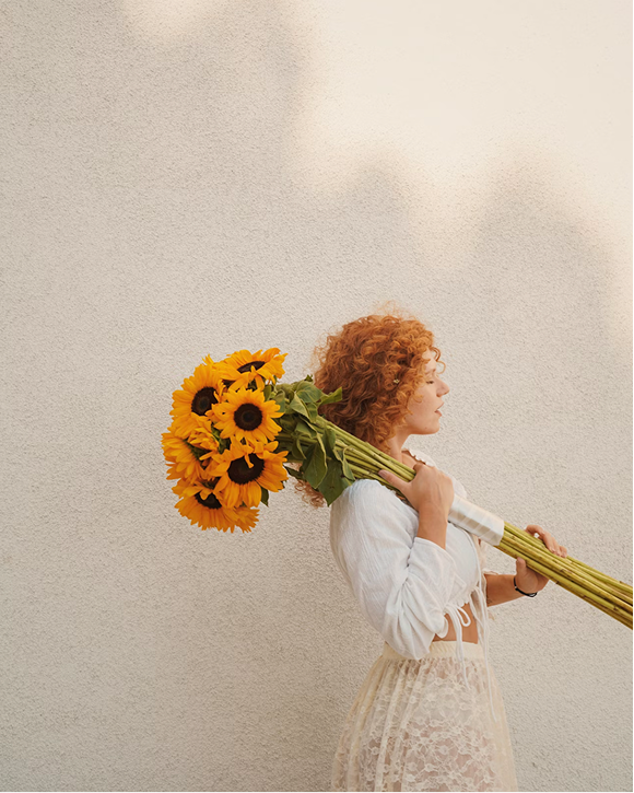 Person holding yellow sunflowers