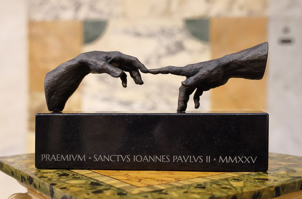 Premio San Giovanni Paolo II award sculpture showing two hands reaching toward each other